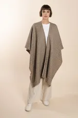 Ruana marrón con diseño a cuadros blancos, terminación envivada y flecos cortos.