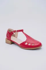 Sandalias bajas negras de cuero con pulsera al tobillo y talón cubierto. Presentan aberturas circulares en la capellada y taco de madera.