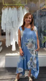 Vestido largo azul con estampado floral, sin mangas, escote redondo y volado en el ruedo.
