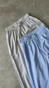 Pantalón largo a cuadros color beige y blanco, de corte palazzo y tiro alto.