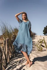 Vestido celeste de lino con mangas cortas y falda midi con volados de seda.