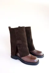 Bota negra de cuero con caña alta y detalle de cobertura de gamuza negra en la parte superior.