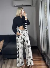 Pantalón palazzo blanco con estampado de motivos tribales en negro, cintura elástica y bolsillos laterales. Talle único.