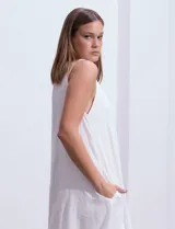 Vestido blanco de crepe, con escote redondo, sin mangas y botones frontales.