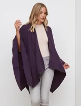 Ruana de tejido suave color morado oscuro, con cuello redondo y corte amplio tipo capa.