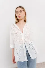 Camisa celeste de algodón liviano con bordado calado tipo broderie, manga larga con puño angosto y botones al frente.