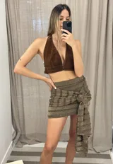 Minifalda gris con lurex, con lazo en la cintura.