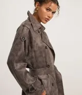 Trench coat largo color marrón con efecto teñido, cuello inglés, manga larga, cierre doble con botones delanteros y cinto para lazo en la cintura.