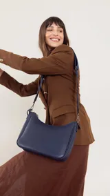 Bandolera morral negra de símil cuero, con cierre trasero y división interna. Incluye correa de galón ajustable.