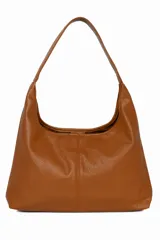 Cartera tipo hobo de cuero sintético color marrón claro, con correa de hombro y cierre superior con cordón ajustable.