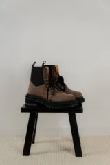 Borcego de gamuza color verde militar con elásticos laterales negros, cordones negros y suela de goma negra con plataforma.