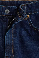 Bermuda de denim azul oscuro, de tiro alto y corte recto, con cinco bolsillos, cierre frontal con botón y trabillas para cinturón.
