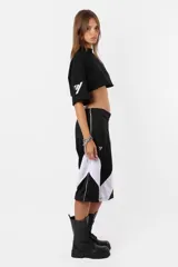 Remera corta negra de calce oversize confeccionada en jersey de algodón. Cuello de ribb ancho, ruedo al corte y estampa en la manga derecha.
