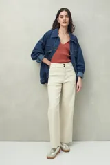 Pantalón ancho color crema, de tiro alto, con pretina y doble botón metalizado.