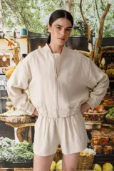 Bomber color beige confeccionada en mezcla de algodón y lino, con cierre frontal y bordado grande en la espalda inspirado en la colección La Verdulería.