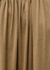 Mono largo color ocre, de corte recto y palabra de honor. Presenta detalle fruncido en el escote y bajo abullonado.