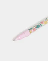 Lapicera con tinta negra, cuerpo de plástico transparente con estampado de flores y adorno de peluche en forma de frutilla.