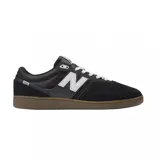 Championes New Balance NM508SBA negros con detalles en blanco y suela marrón.