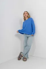 Sweater azul de punto medio, amplio, suave, con escote a la base y puños en mangas y en acabado inferior.