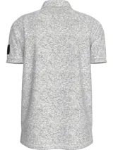 Chomba gris jaspeado de piqué de algodón peinado, con cuello clásico y tapeta de dos botones. Tiene mangas cortas, dobladillo con aberturas laterales y logo de Calvin Klein en la manga.