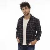 Camisa Wrangler de franela a cuadros en tonos azul marino, rojo y blanco. Tiene dos bolsillos con solapa abotonada en el pecho y cierre frontal con botones.