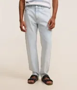 Pantalón de jeans celeste, corte slim, con bolsillos delanteros y traseros, trabillas en la cintura y cierre tradicional con botón y cremallera.