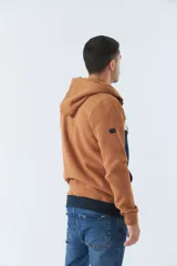 Campera con capucha color marrón, azul y blanco, con cierre frontal y bolsillos tipo canguro.