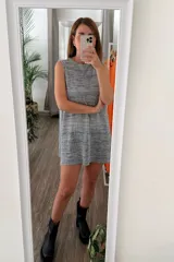 Vestido tejido de punto sin mangas, corte recto y holgado, con cuello redondo. El tejido es jaspeado en tonos grises, azules y amarillos claros, con brillo sutil de lurex.