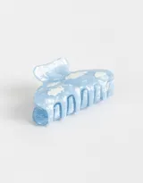 Broche para el pelo de plástico celeste con estampado de nubes blancas.