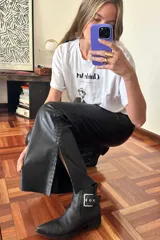 Pantalón Oxford negro de cuero sintético con cierre frontal y aberturas laterales con pasamanería plateada.