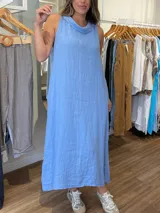 Vestido largo celeste de lino, corte recto y cuello buche.