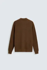 Polo marrón de corte relaxed fit, tejido en punto de algodón. Tiene cuello solapa con cierre frontal de botonadura, manga larga y acabados en rib.