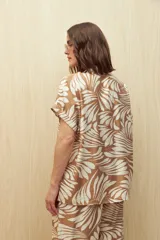 Camisa de manga corta con estampado de hojas en tonos azul y blanco, con botones frontales y puños con vuelta.