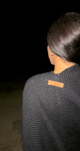 Ruana de lana merino negra, con diseño abierto y tejido suave.