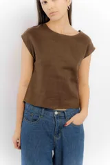 Remera color crudo de lino, sin mangas y con tajo en la espalda.