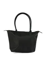 Bolso tipo tote negro de tela impermeable, con doble asa de mano y cierre superior con cremallera. Incluye un colgante decorativo de cordón blanco y negro.