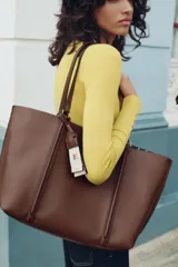 Bolso negro tipo shopper con asa de hombro, detalle de colgador y bolsillo interior maxi. Cierre mediante imán.