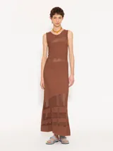 Vestido largo color marrón, de tejido frío y corte ajustado. La parte superior es sin mangas y combina tejido con organza transparente.