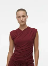 Top corto sin mangas color vino tinto (Syrah) con escote cruzado en V y frunces drapeados en el torso.