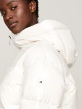 Campera puffer blanca de nailon con relleno de plumón, capucha fija, cierre de cremallera, puños elásticos y dos bolsillos delanteros.