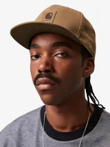Gorra marrón de lona de algodón con diseño de seis paneles, paneles frontales reforzados, visera plana y logo cuadrado de Carhartt bordado en el frente.