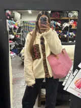 Campera de corderito color crudo, forrada con polar y detalles en sherpa con estampado animal print.