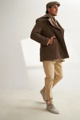 Saco marrón de lana con solapa, doble abotonadura, bolsillos, canesú y charreteras.