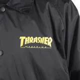 Campera negra tipo windbreaker con cuello camisero, cierre frontal con botones a presión, bolsillos laterales y logo de Thrasher en amarillo en el pecho.