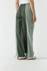 Pantalón verde con corte ancho, bolsillos laterales y cintura ajustable con cordón.