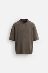 Polo marrón de punto con textura acanalada, corte relaxed fit, cuello solapa y cierre frontal con botonadura. Manga corta y terminaciones en rib. Efecto lavado.