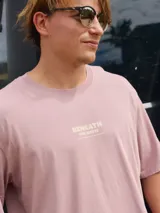 Camiseta manga corta color lila con estampado en la espalda de palmeras, sol y olas. Corte holgado y cuello redondo. Confeccionada en jersey simple 100% algodón.