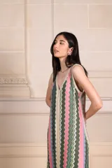 Vestido largo de punto con estampado vertical en tonos rosa, verde y beige. Tiene escote en V tanto en la parte delantera como en la espalda, y detalle de lurex en los bordes.