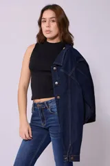 Campera de jean de color azul oscuro, con corte cropped y costuras en contraste color caramelo. Presenta cuello clásico, cierre frontal con botones metálicos y bolsillos a la altura del pecho y laterales.