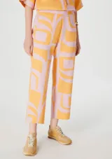 Pantalón capri de lino color rosa con estampado abstracto naranja.